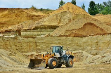 pexels-photo-461789-461789 An excavator working in an open pit mine surrounded by sandy terrain and clear sky.